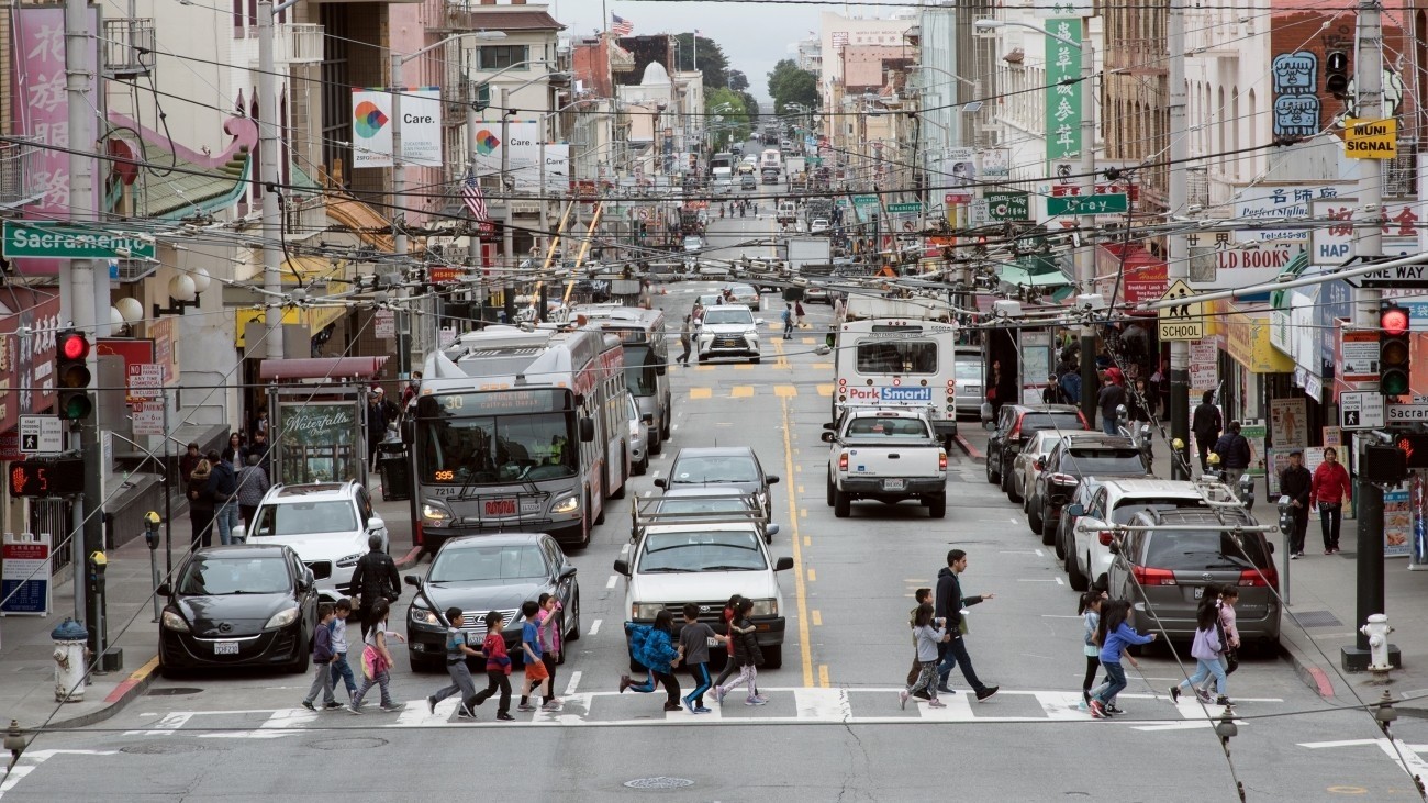people walking across a street in Chinatown