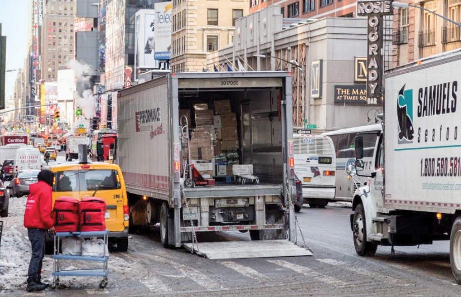 A double parked truck unloading in crowded conditions
