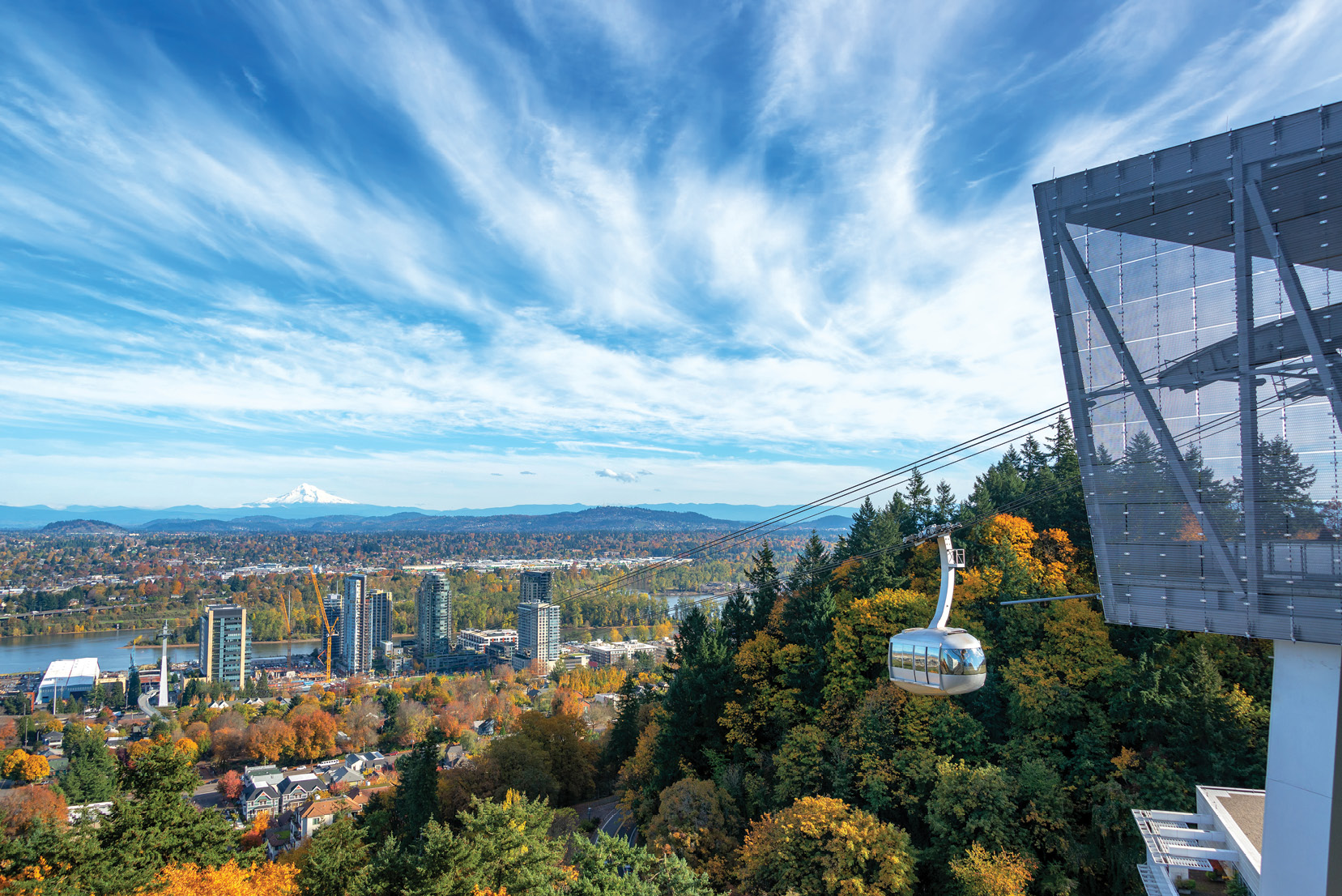The Portland Aerial Tram suspended above Portland, Oregon, with the city skyline visible in the background.