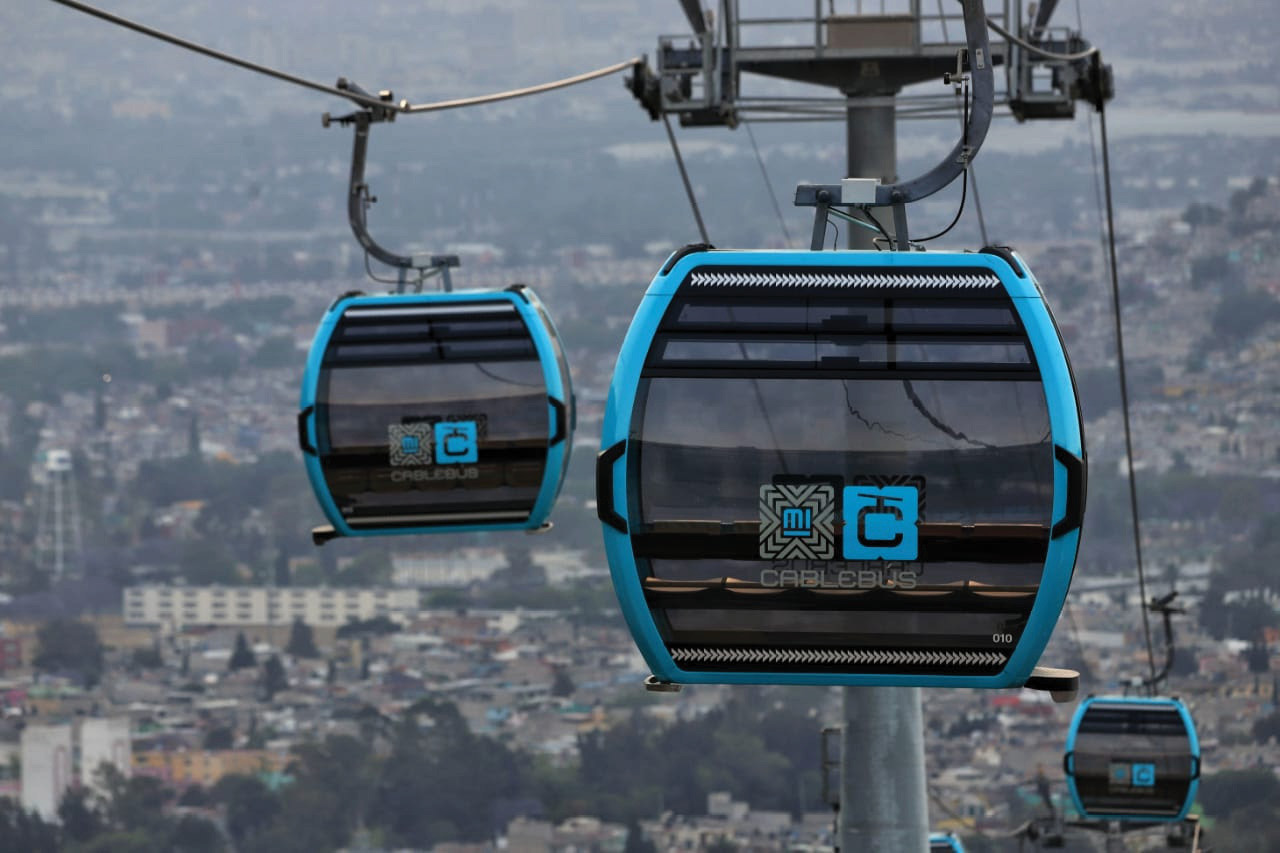The Mexico City Cablebús system, showing cabins operating above a dense urban neighborhood.