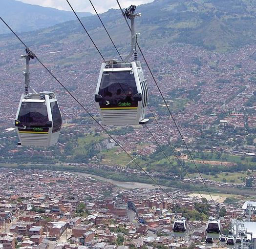 The Metrocable system in Medellín, Colombia, showing cabins traveling above hillside neighborhoods.