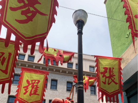 A close up of yellow banners with Chinese text printed in red, strung across an alleyway.