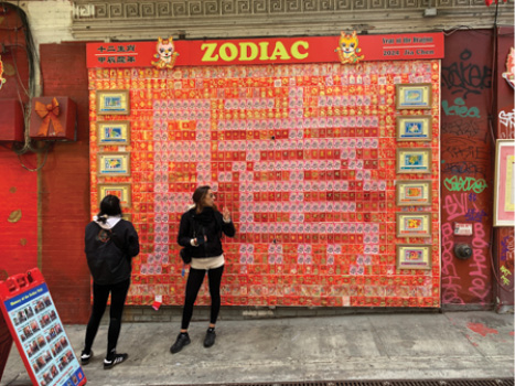 A collage labeled “Zodiac” with a large Chinese character made with pink envelopes against a background of red envelopes with gold lettering.