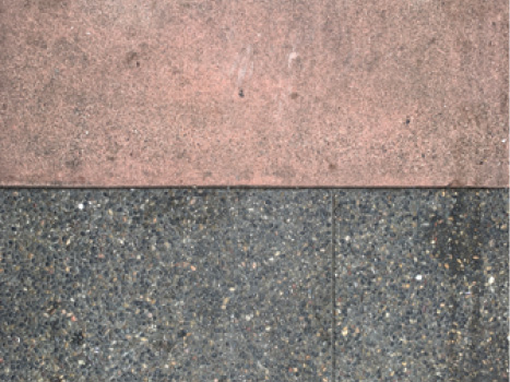 A close up of a thick stripe of light pink concrete above a thick stripe of dark concrete.
