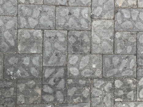 A close up of small square tiles, with a light grey oval pattern against a darker grey background.