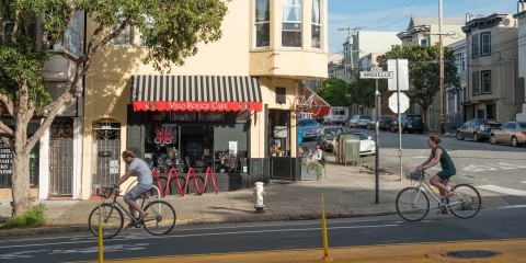 Bicyclists in a bike lane in front of a cafe on Arguello in the Inner Richmond