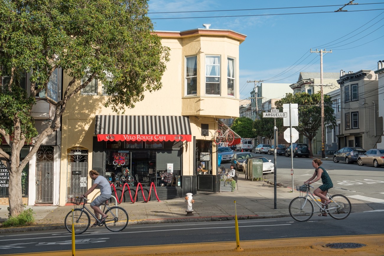 Bicyclists in a bike lane in front of a cafe on Arguello in the Inner Richmond