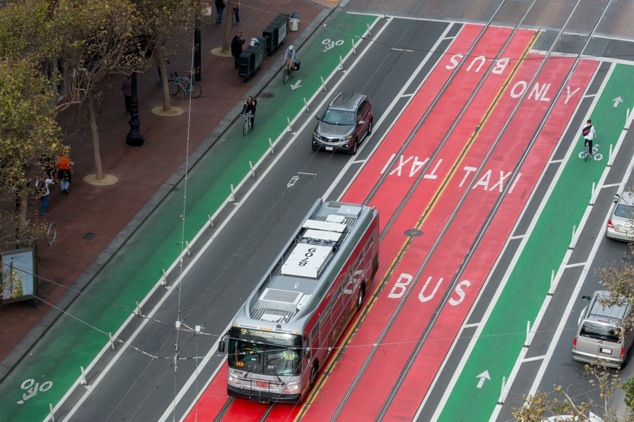 A bus in a red bus-only lane on Market Street, surrounded by green bike lanes.