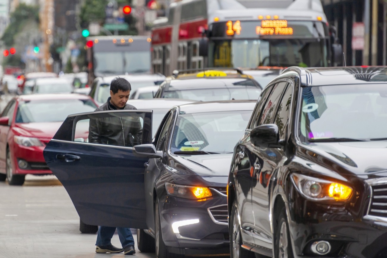 A man entering a Lyft ride-hail vehicle. Photo credit: Sergio Ruiz