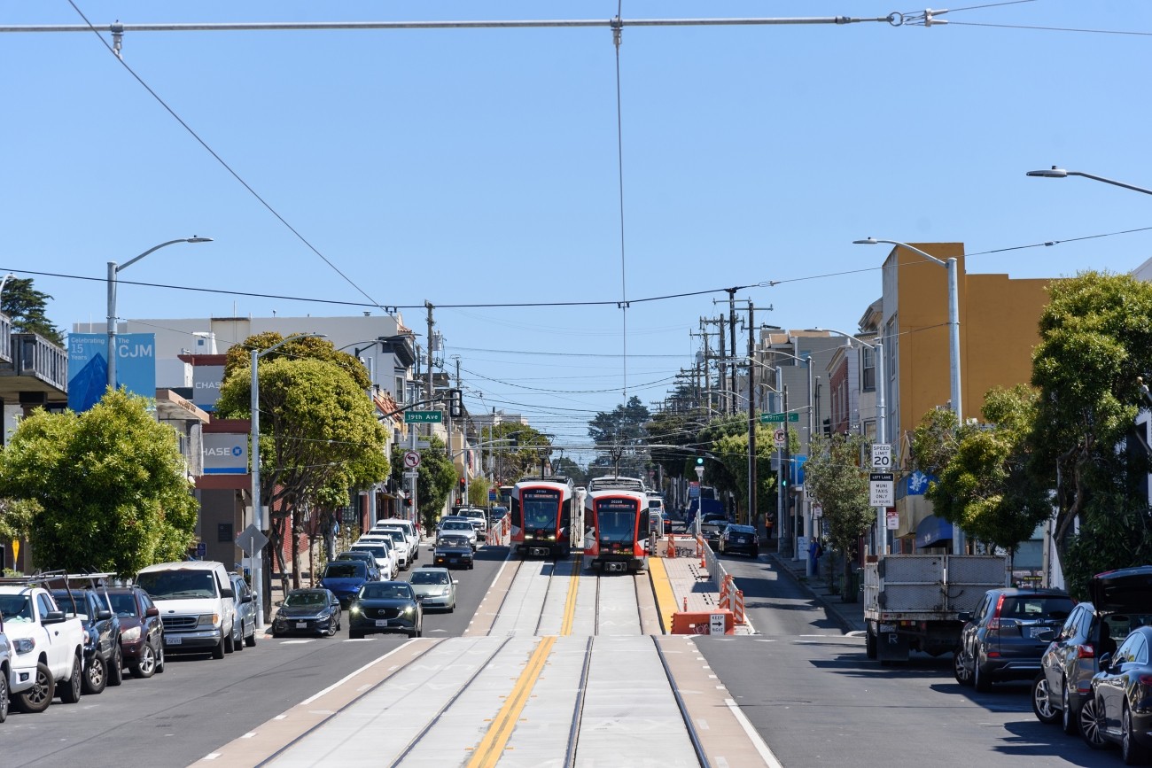 Two Muni Metro light rail vehicles pass each other on Taraval at 19th Avenue