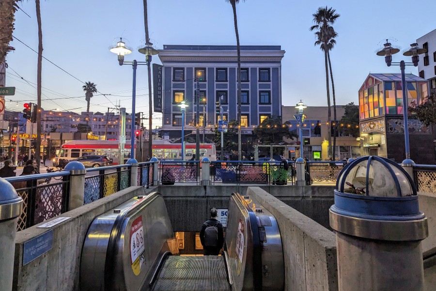 A person rides down the escalator at the 16th Street / Mission BART plaza.