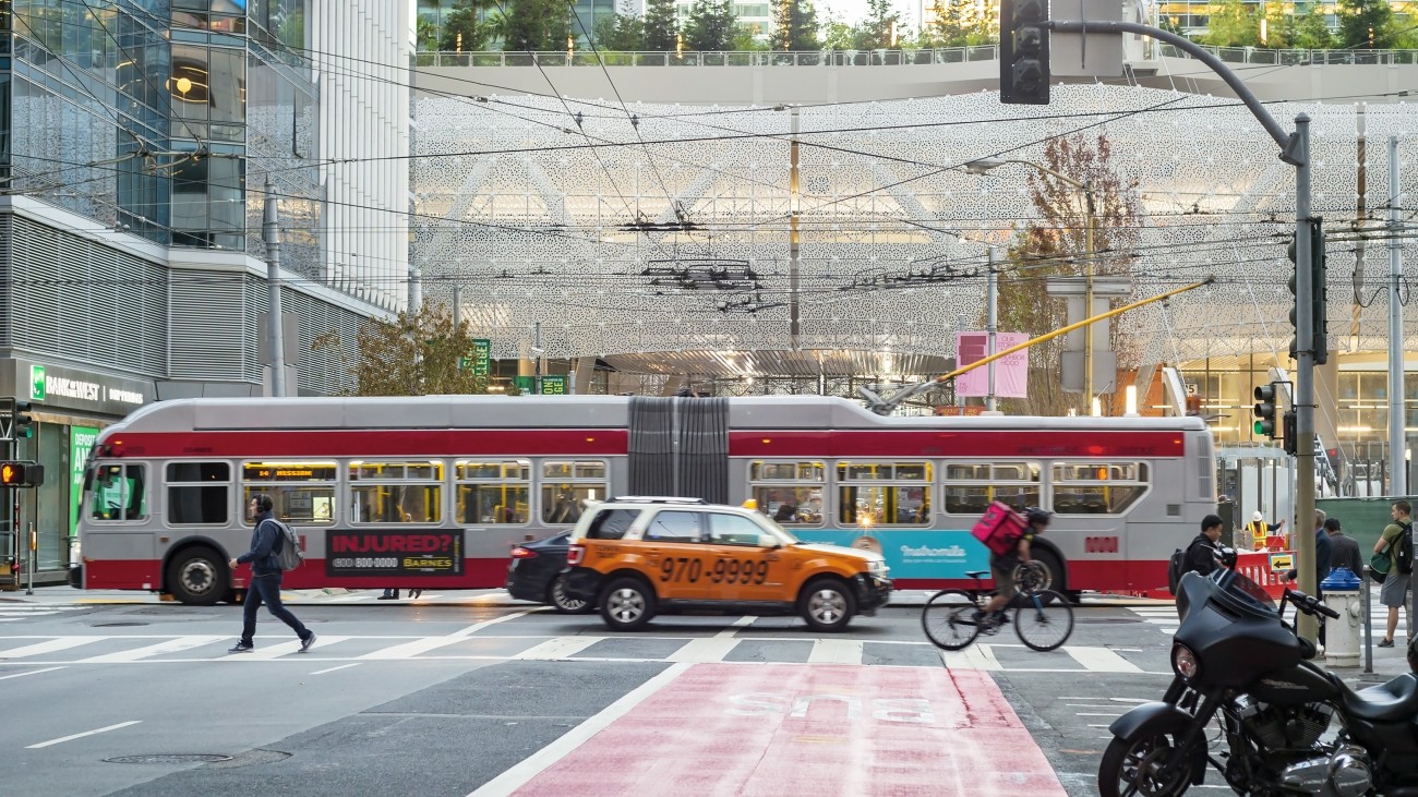 A view of the Salesforce Transit Center, a red transit-only lane, and a bus