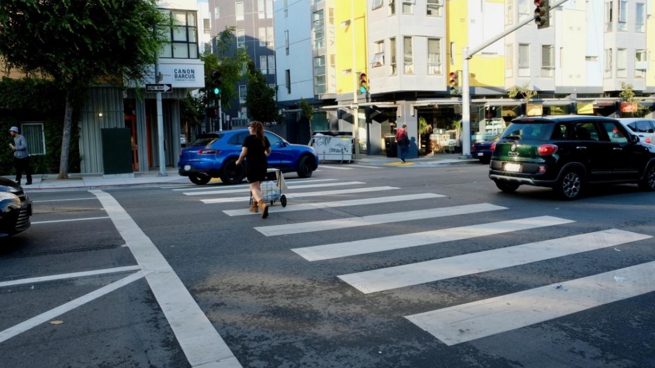 A pedestrian crosses 8th Street.