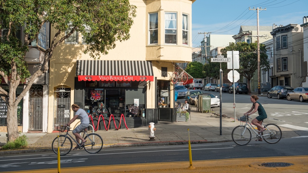 Bicyclists in a bike lane in front of a cafe on Arguello in the Inner Richmond