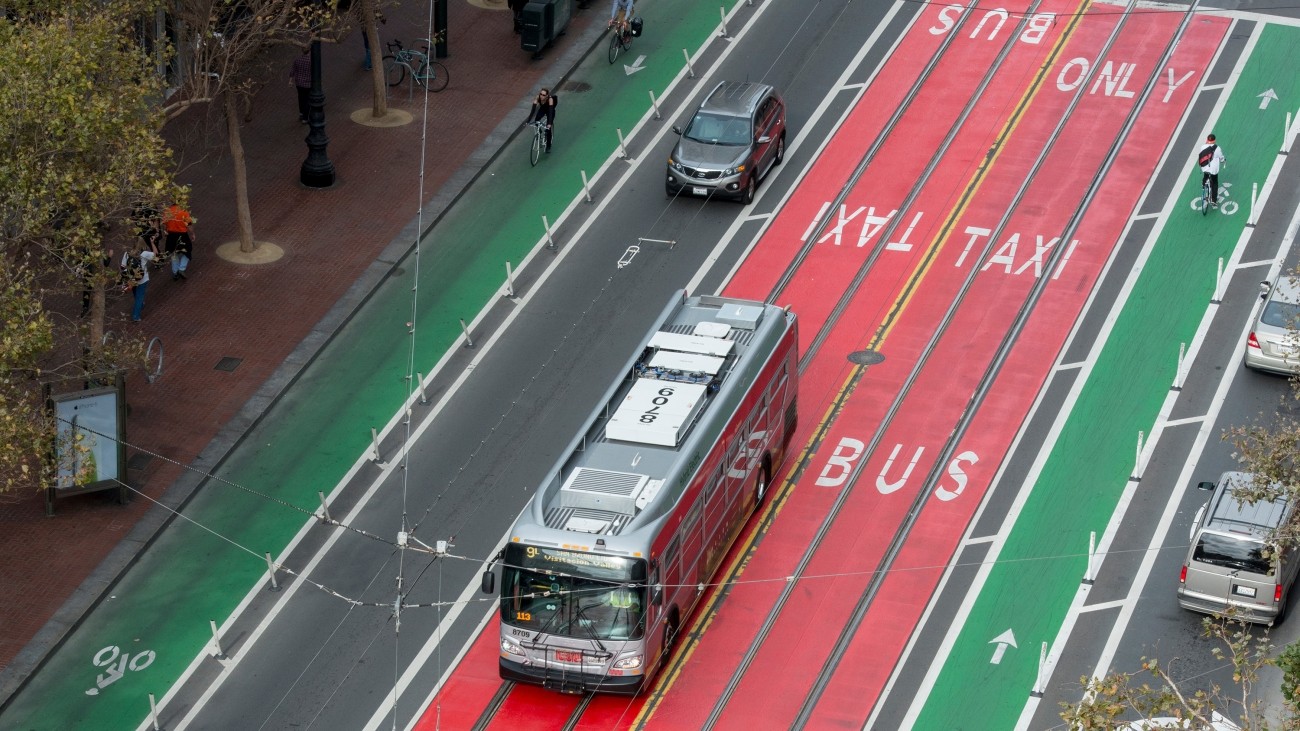 A bus in a red bus-only lane on Market Street, surrounded by green bike lanes.