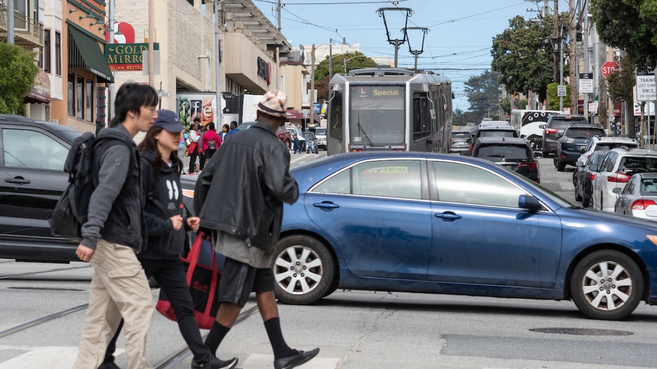 People in a crosswalk walking across 19th Avenue