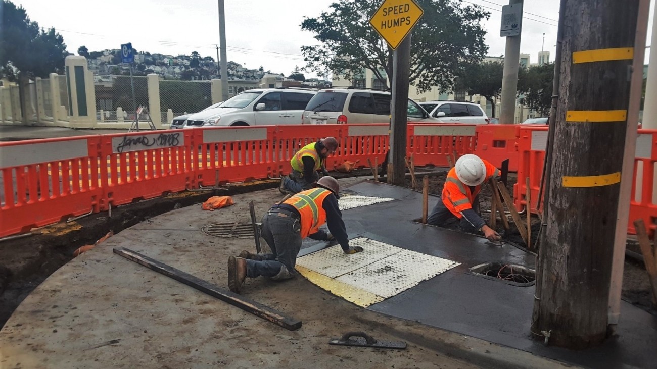 construction workers building a curb ramp
