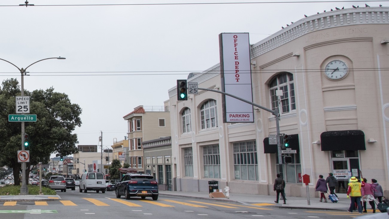 View of Arguello Boulevard with vehicles, pedestrians, and buildings