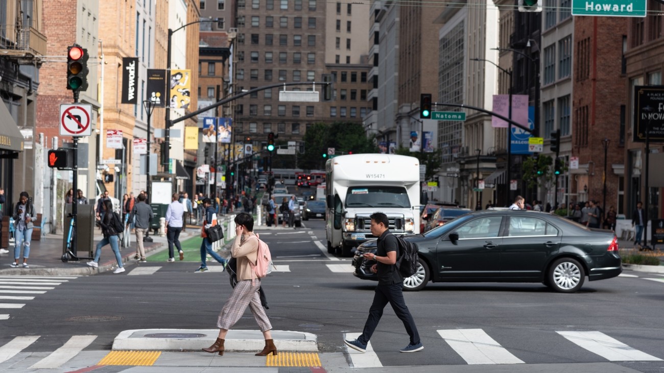 Pedestrians and cars crossing an intersection on Howard Street.