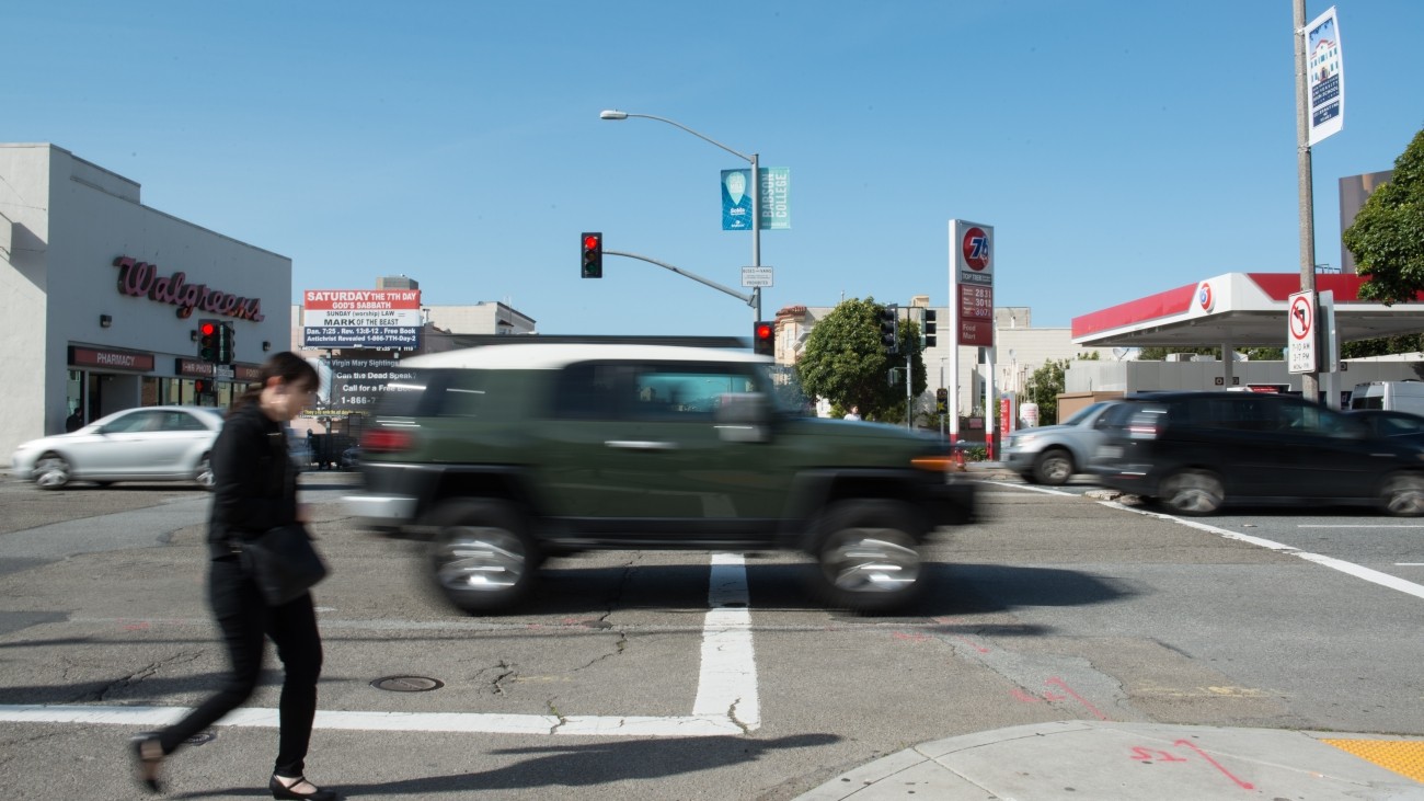 Pedestrian and cars crossing an intersection.