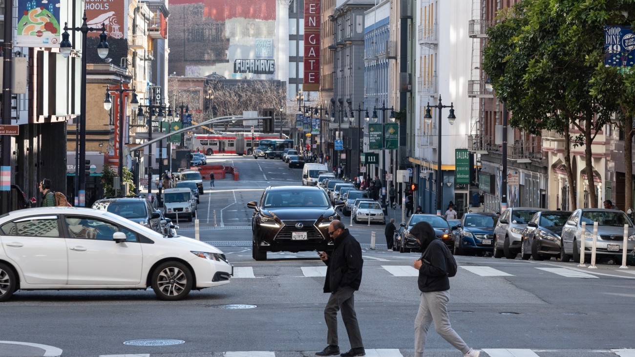 People and cars crossing an intersection on Taylor Street.