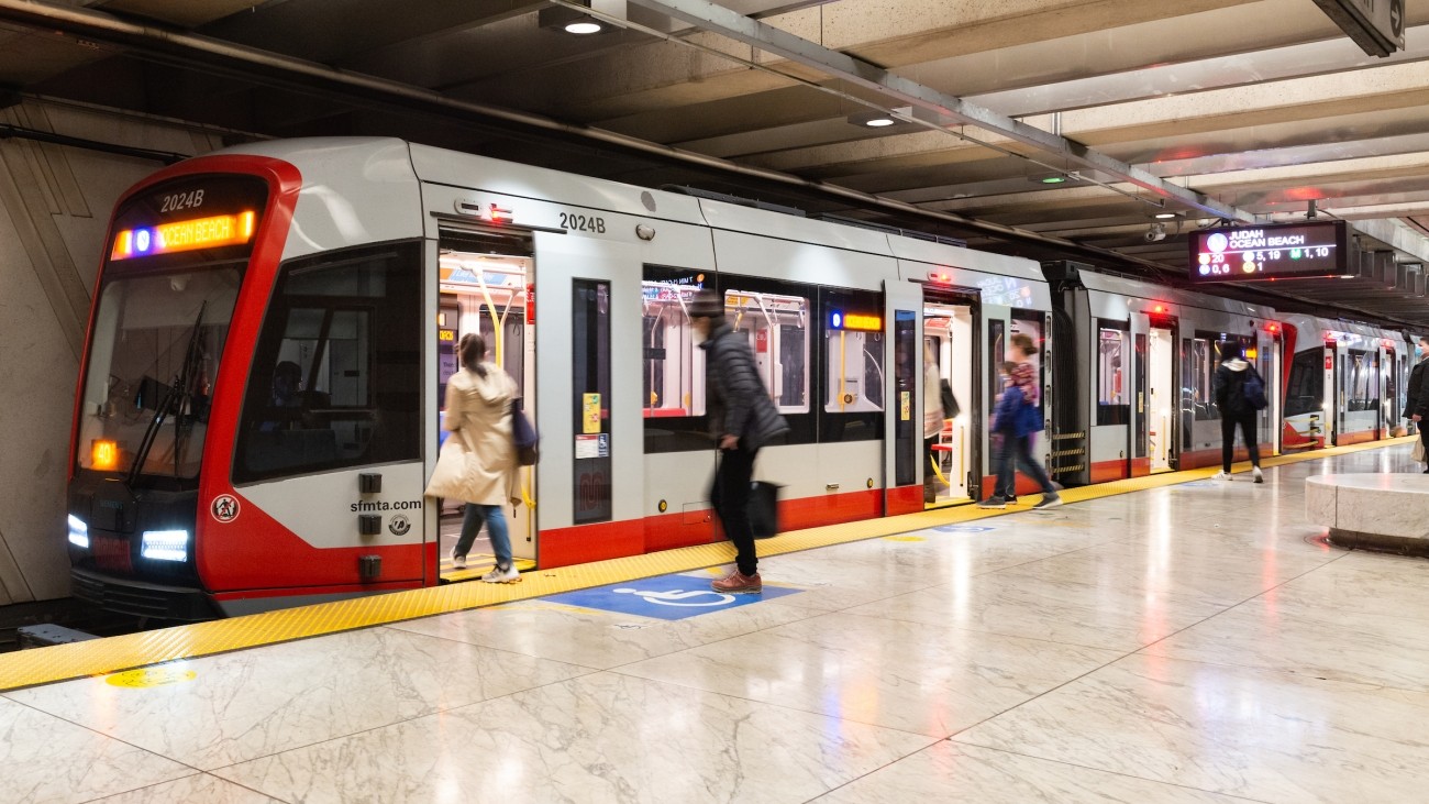 People boarding Muni metro train in underground station 