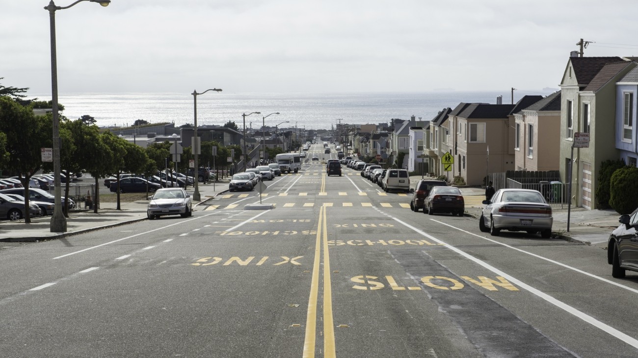 Ortega Street, looking west toward the Pacific Ocean. "Slow school xing" is stenciled on the street.