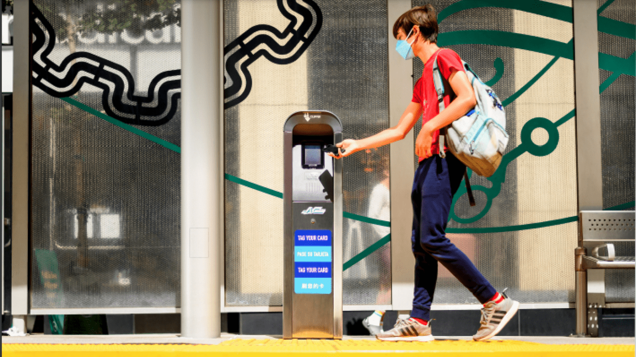 Student swiping Clipper card on platform. 