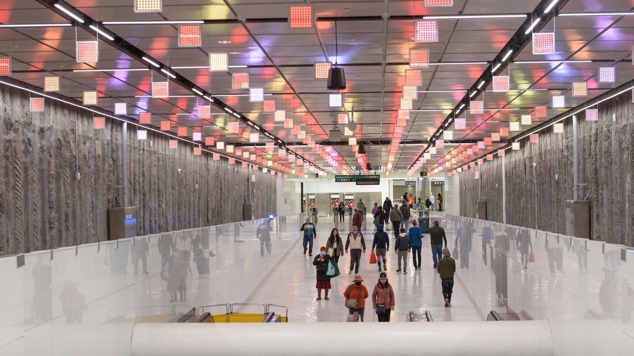 People walking in Central Subway, illuminated decorations hang from ceiling