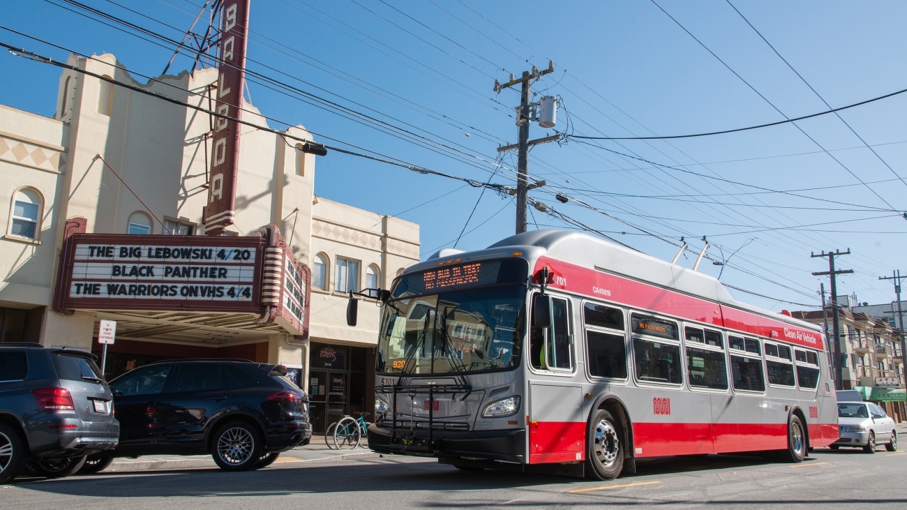 A Muni bus drives by the Balboa Theater located in District 1 in San Francisco.