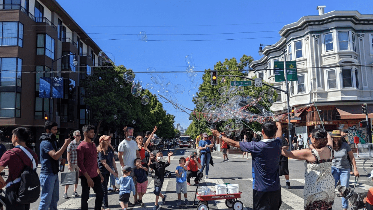 Crowd of people gathered looking at bubbles