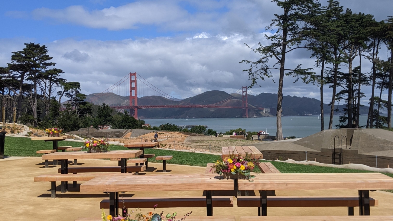 Several new picnic tables fill the foreground at Battery Bluff Park. The Golden Gate Bridge stands in the background.