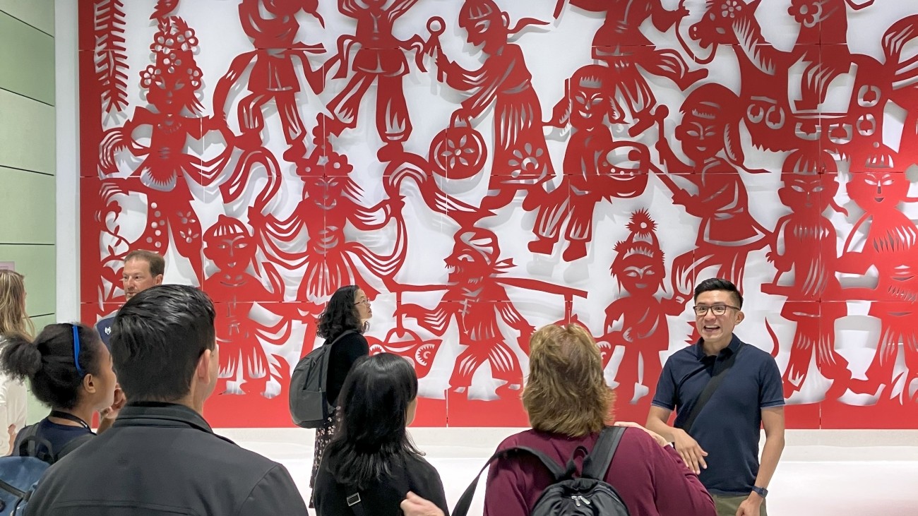 Tour group learning about art work in side Chinatown-Rose Pak Station. 