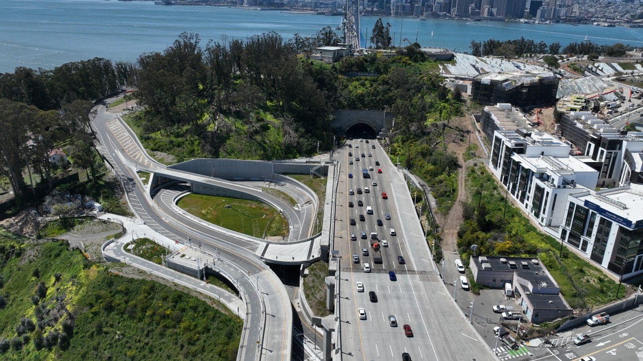 Aerial view of Southgate Road with vehicles on road and San Francisco skyline and Bay Bridge the background