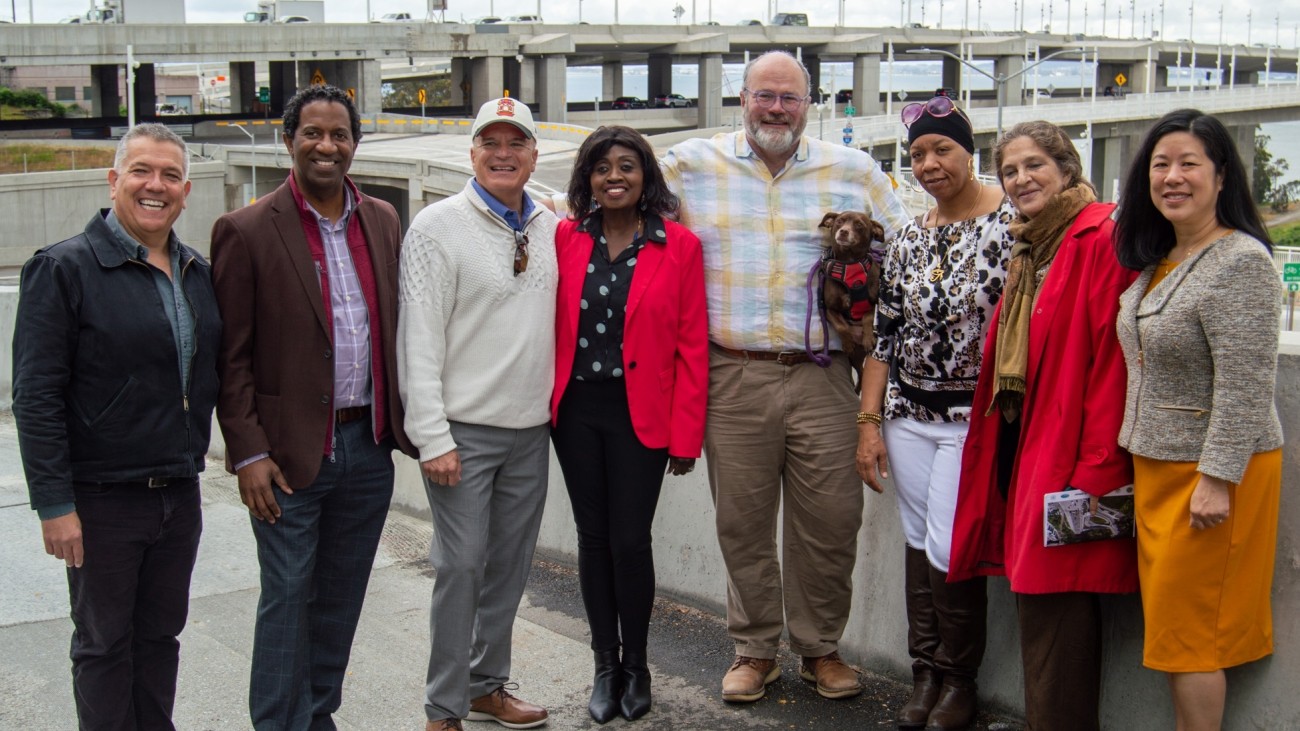 A group of people, including SFCTA Executive Director Tilly Chang and SFCTA Deputy Director for Capital Projects Carl Holmes, stand in front of the newly-finished Yerba Buena Island / I-80 Southgate Road and Interchange Project.