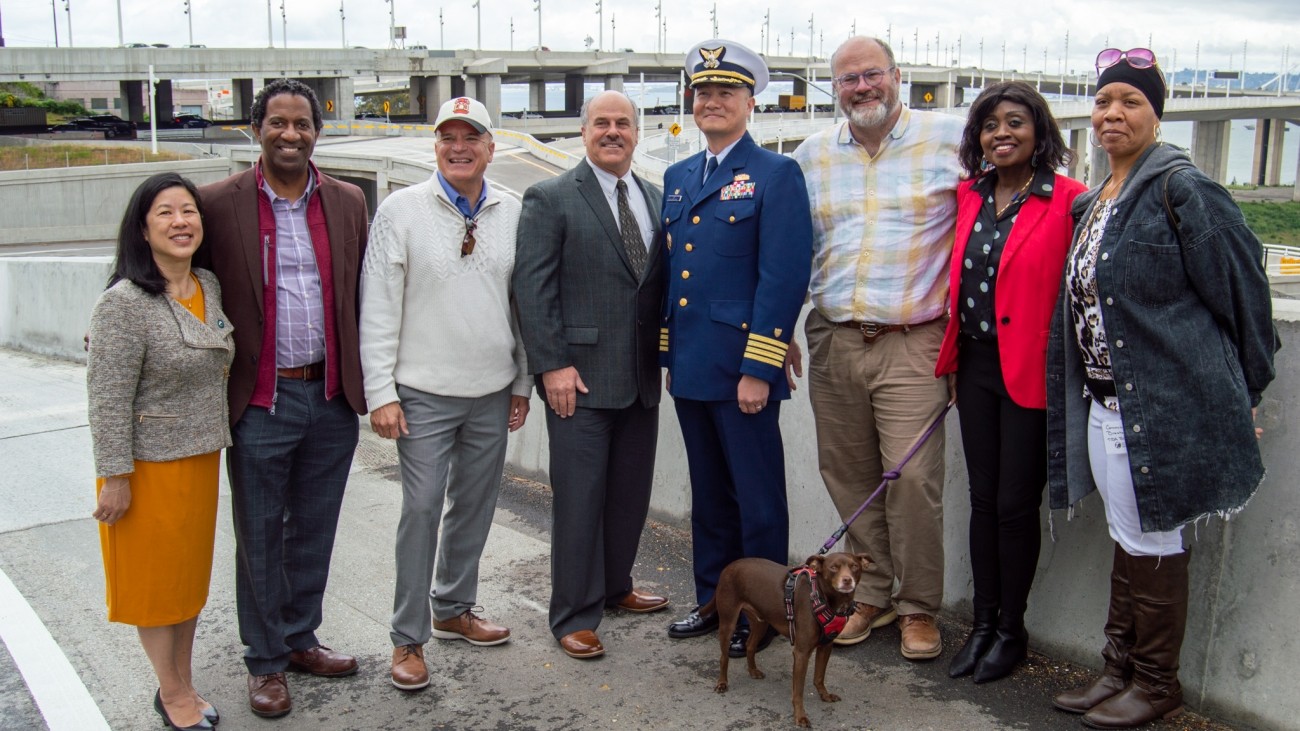 A group of people, including SFCTA Executive Director Tilly Chang and SFCTA Deputy Director for Capital Projects Carl Holmes, stand in front of the newly-finished Yerba Buena Island / I-80 Southgate Road and Interchange Project.