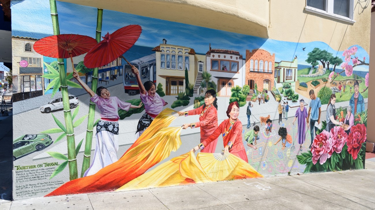 New community mural titled “Together on Taraval,” featuring a L Tarval train, colorful dancers, youth, adults, and homes along Taraval Street