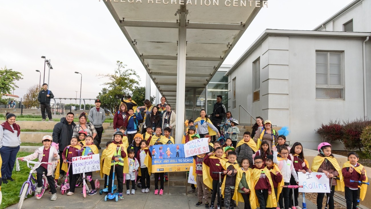 ER Taylor students pictured together with yellow capes, and some with bikes and scooters