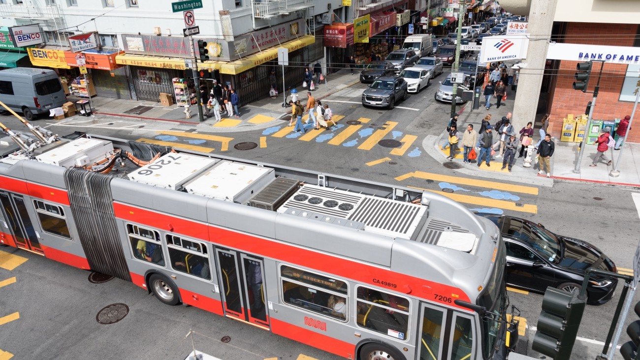 Overhead view of buses, cars, and people on the road in San Francisco's Chinatown