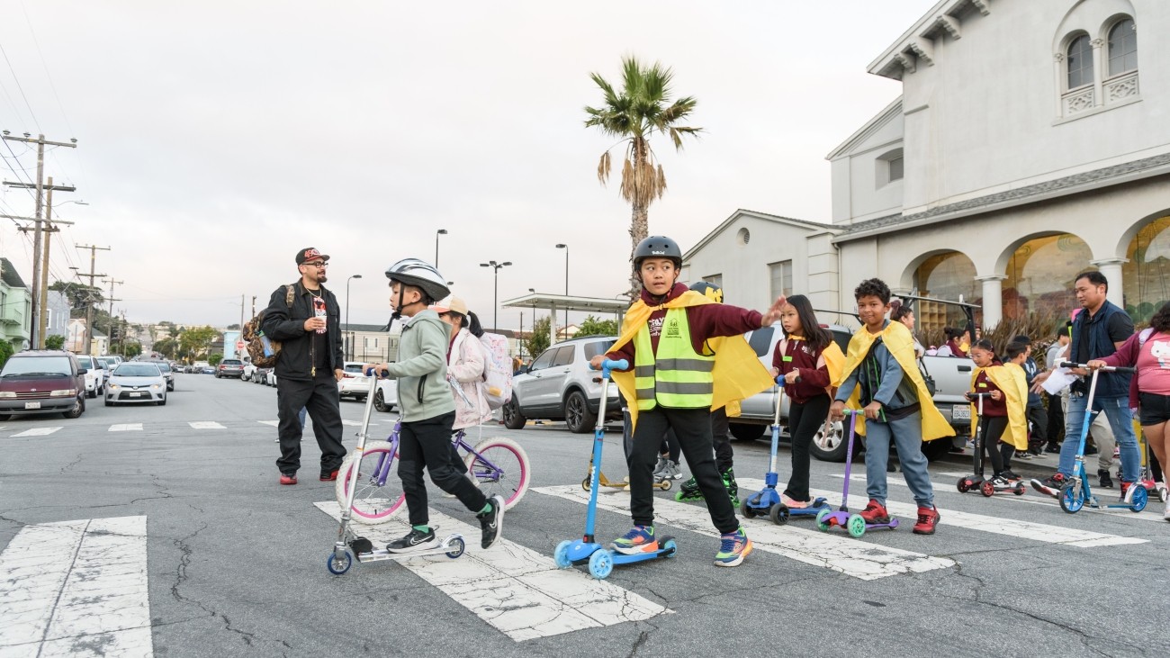 Students on scooters in a crosswalk