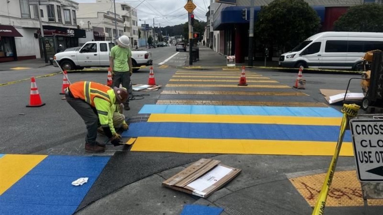 SF Public Works' workers painting a decorative crosswalk along 6th Avenue and Clement Street