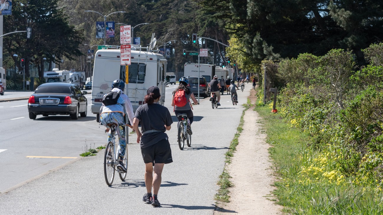 People walking and bicycling near Lake Merced