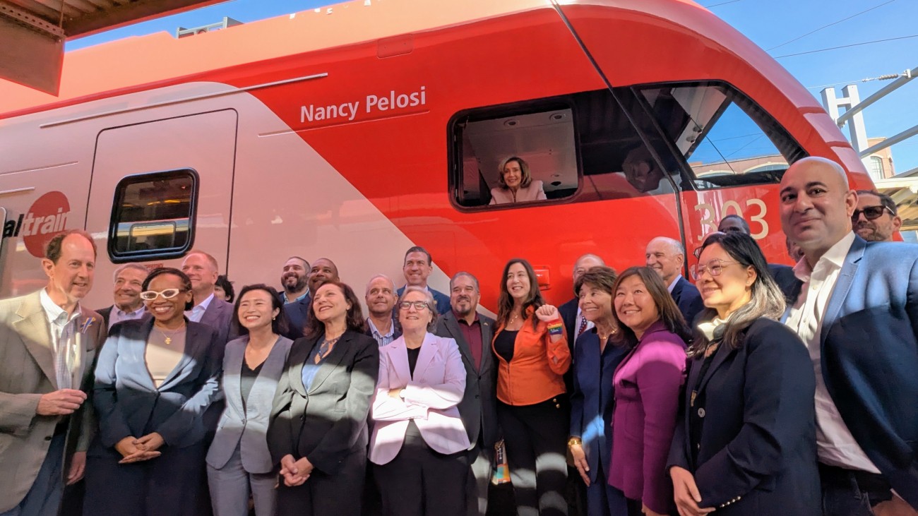 Speaker Emerita Pelosi in pilot with group of electeds in front of train