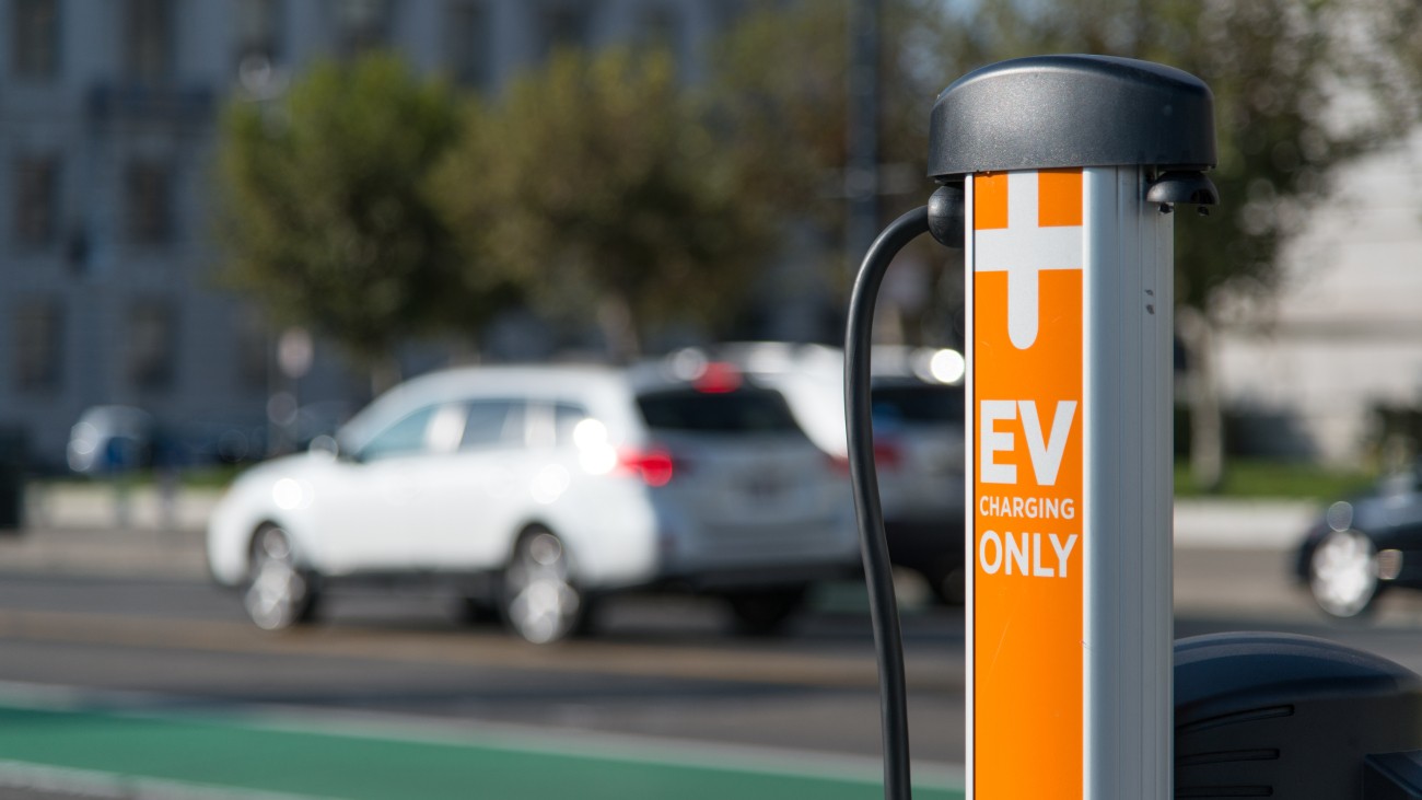 A curbside EV charger, orange pole with text that says "EV Charging Only" 