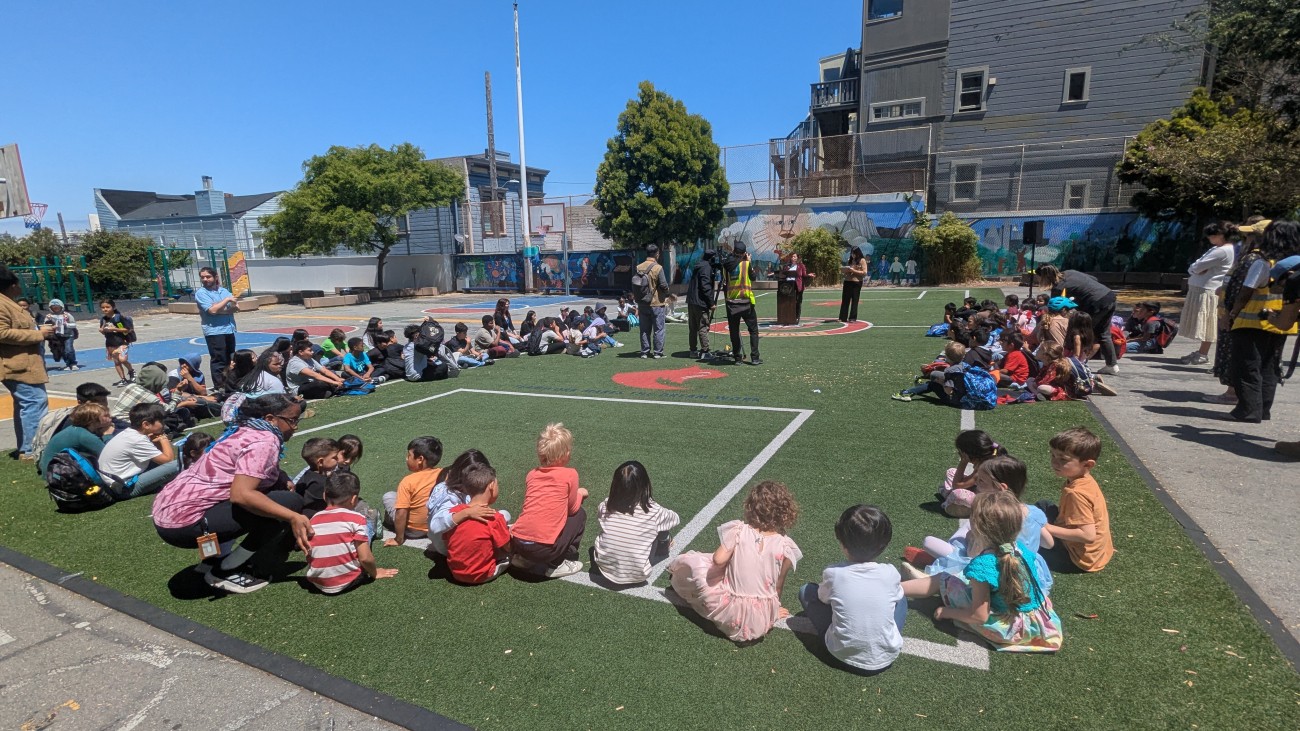Students sitting around a field at John Muir Elementary School