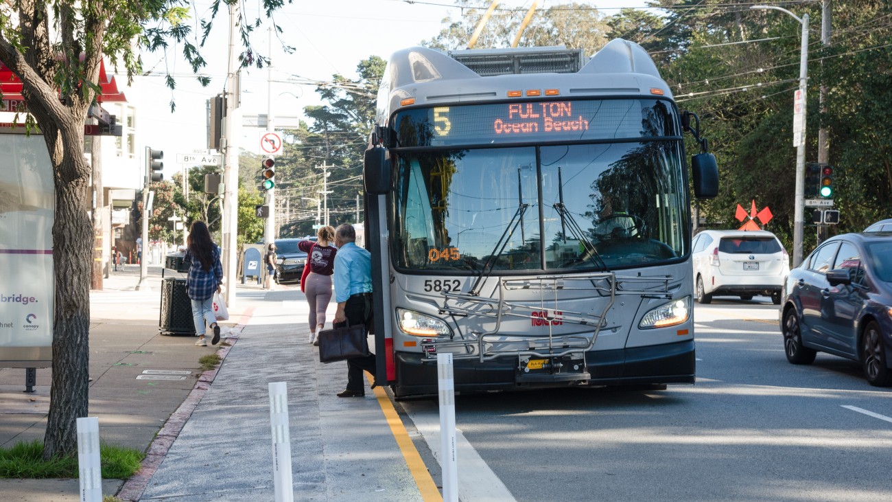 The 5 Fulton Muni bus is stopped at 8th Ave, letting people off