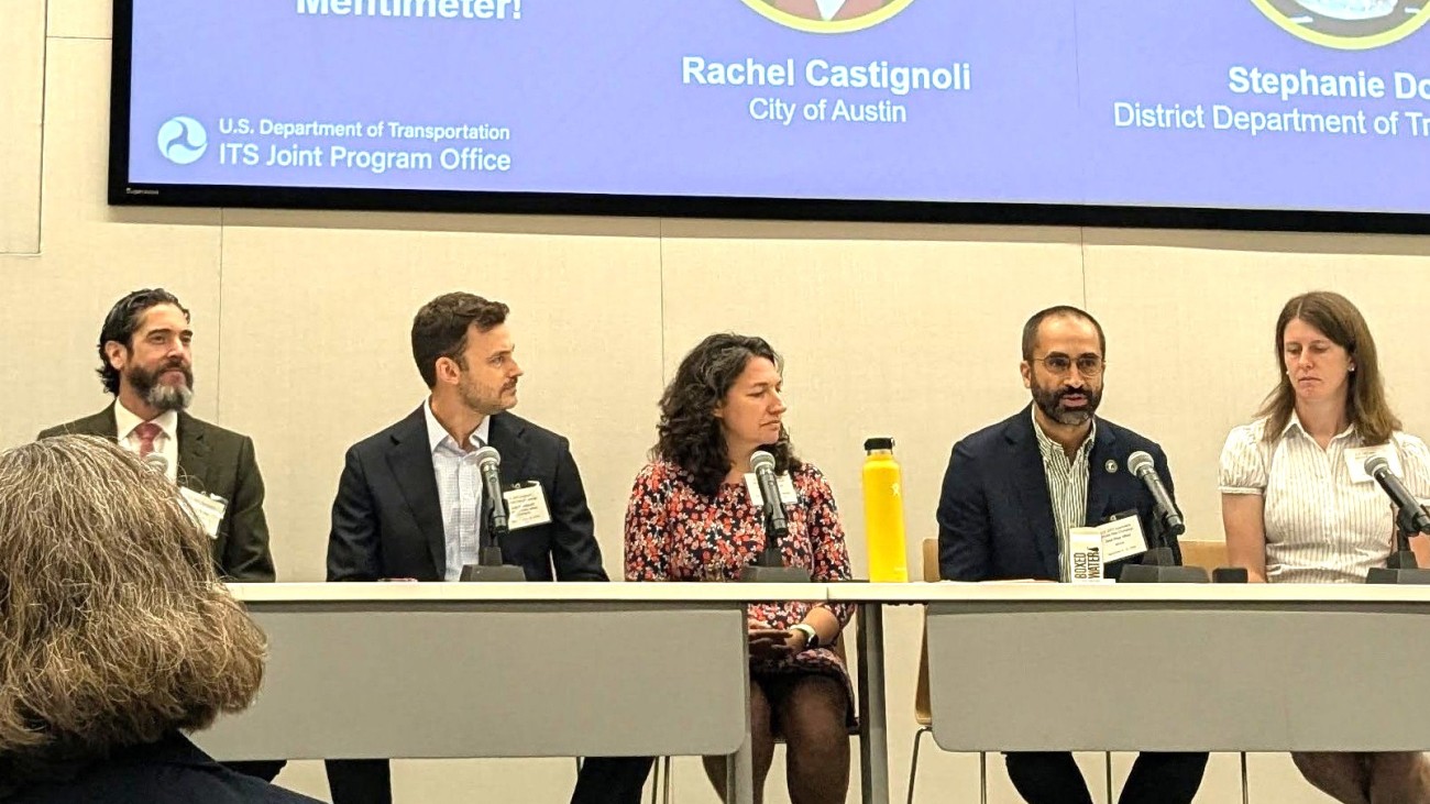 Five panelists speaking in front of an audience