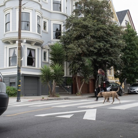 A woman crossing the street in a raised crosswalk