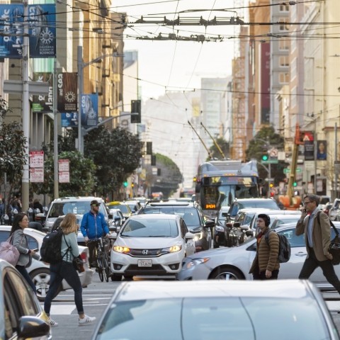 People walking and biking on a congested street downtown