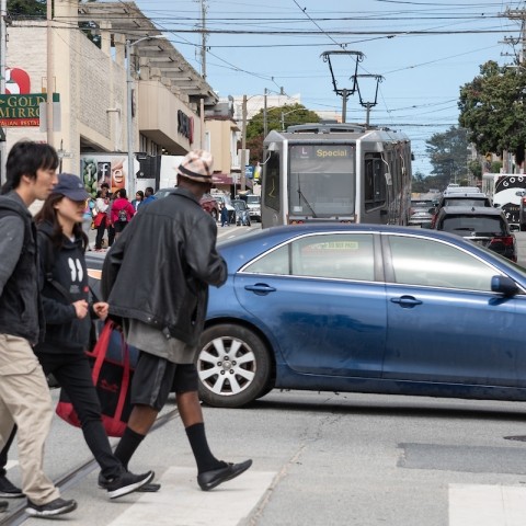 People in a crosswalk walking across 19th Avenue